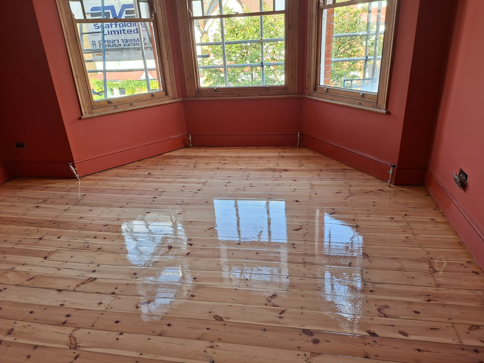 Clapham Floor Sanding finished Victorian pine softwood floorboards in a Clapham bay window room, showing a freshly lacquered, glossy solid wood surface.