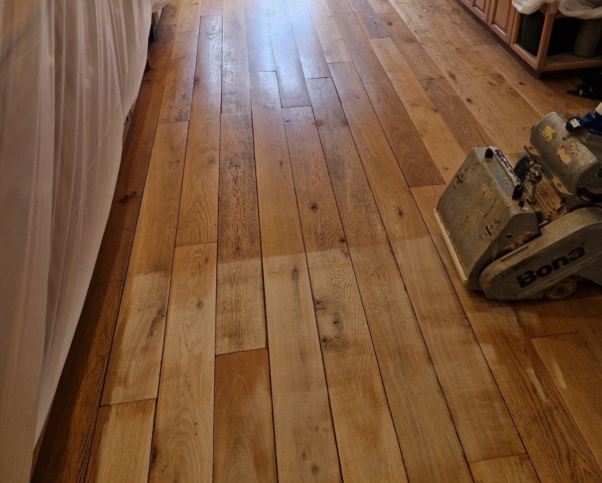 Clapham Floor Sanding in progress on oak hardwood floorboards, showing a mid-sanding transformation between old finish and freshly sanded timber.