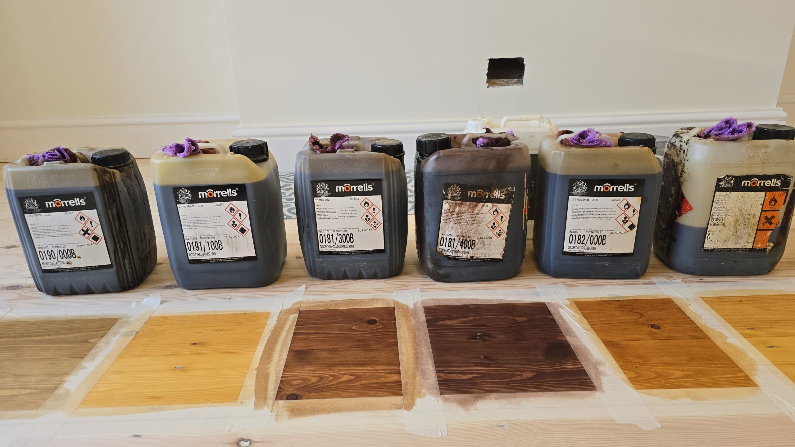 Clapham Floor Sanding stain samples on pine softwood floorboards in a Clapham home, showing different Morrells colour options tested on the sanded wood.